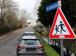 Am kommenden Montag erfolgt der Baustart in der Straße "Am Gänsewinkel". © Stadt Schönebeck (Elbe) Zwei Autos stehen auf einer Schotterstraße neben einem Wassergraben.