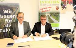 Landrat Markus Bauer und Oberbürgermeister Bert Knoblauch bei der Unterzeichnung der Vereinbarung.