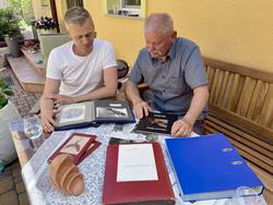 Enkel Matthias und Sohn Arnim Malkowsi blättern in Fotoalben zu ihrem Opa beziehungsweise Vater Dario Malkowsi.