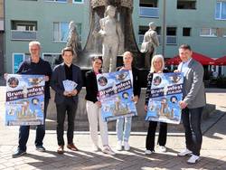 Präsentieren die Plakate fürs Brunnenfest (vl.l): Veranstalter Carsten Mende von Maxi-Top, Vorstandsmitglied Matthias Goldschmidt von der WBG, Geschäftsführerin Julia Teige von den Stadtwerken, Elisabeth Dancsó, Amtsleiterin Bildung, Kultur, Soziales und Sport, Constanze Pohlan, Mitarbeiterin Sachgebiet Kultur und Sport, sowie Karsten Fiedler, Geschäftsführer der SWB. © Stadt Schönebeck (Elbe) Sechs personen stehen vor einem Brunnen und präsentieren Plakate für die Veranstaltung.