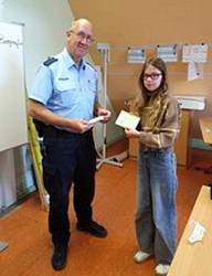 Ein Polizist und eine Schülerin der 4. Klasse mit einem Fahrradführerschein.