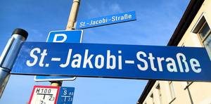 Das alte Straßenschild (oben) wird gegen das neue getauscht.