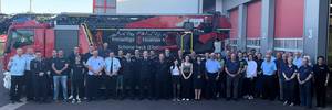 Feuerwehrmänner und -frauen stehen vor einem Feuerwehrauto.