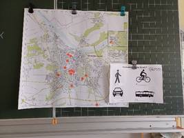 Eine Straßenkarte hängt an der Tafel.