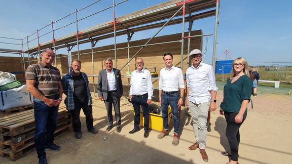 Waren bei der Freilegung der Stampflehmwände (v.l.): Detlef Büttner, Fachdienst Bauordnung und Hochbau, Salzlandkreis, Hubert Heinrichs, verantwortlicher Lehmbauer vor Ort und Ausbilder, Dr. Gunnar Schellenberger, Präsident des Landtags Sachsen-Anhalt, Dr. Alfred Reichenberger, Landesamt für Denkmalpflege und Archäologie Sachsen-Anhalt, Prof. Christof Ziegert, Lehmbau-Experte, Dachverband Lehm e.V., Carsten Sußmann, Architekt des ausführenden Architekturbüros, Nora Beyer, Stabstelle Digitalisierung und Innovation beim Salzlandkreis. © Salzlandkreis 20210907 Entschalung Lehmbau 1 RHP ©Salzlandkreis