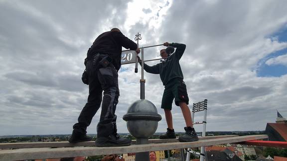 Eine Grußbotschaft an die Nachwelt findet Platz in einer Dokumentenhülse und wird – eingeschlossen in die Kugel – mit der Wetterfahne auf den sanierten Turm des Museumsdachs gesetzt. © Salzlandkreis 20210719 132805 resized 1 ©Salzlandkreis