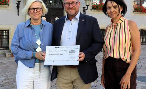 Den symbolischen Scheck überreichte ÖSA-Geschäftsstellenleiterin Heike Wehemeyer an Schönebecks Oberbürgermeister Bert Knoblauch und Mitarbeiterin Kirstin Herrmann © Stadt Schönebeck (Elbe) Den symbolischen Scheck überreichte ÖSA-Geschäftsstellenleiterin Heike Wehemeyer an Schönebecks Oberbürgermeister Bert Knoblauch und Mitarbeiterin Kirstin Herrmann
