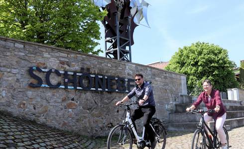Stadtradeln geht in die nächste Runde. © Stadt Schönebeck (Elbe) Zwei Radelnde fahren vor dem Schriftzug Schönebeck und der Salzblume entlang.