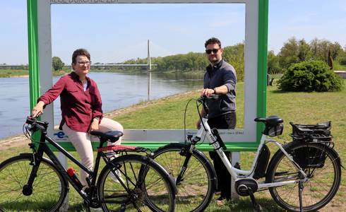 Zwei Menschen stehen an einem großen Bilderrahmen vor der Elbe und der Elbauenbrücke.