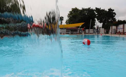 Ein Wasserball schwimmt vor einem kleinen Wasserfall im Nichtschwimmerbecken.