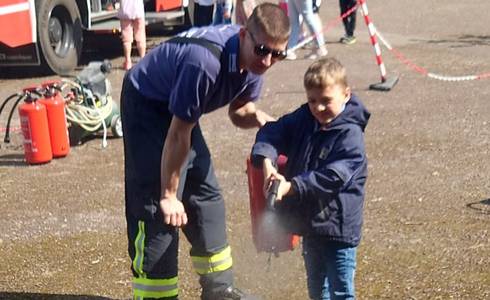 Schulkinder üben den Umgang mit Löschmitteln